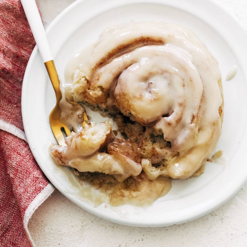 Cinnamon roll on a plate with a fork.