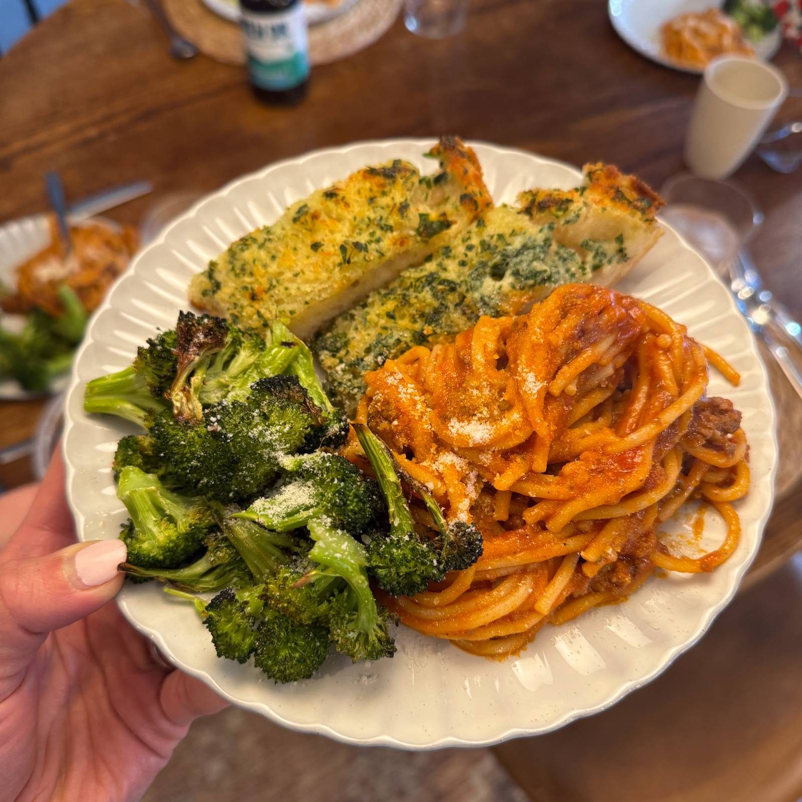 Instant pot spaghetti on a plate with garlic bread and broccoli.