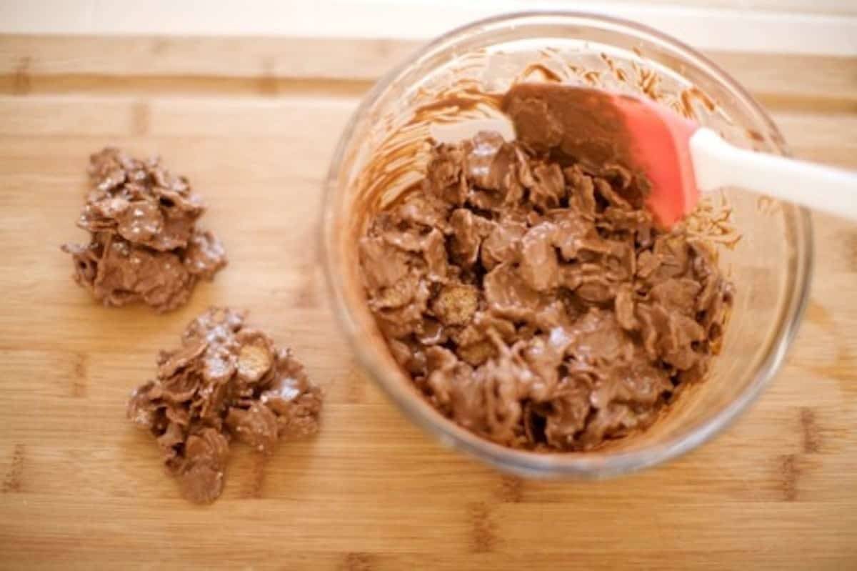 Mixing nutella and peanut butter with cereal to make peanut butter clusters.