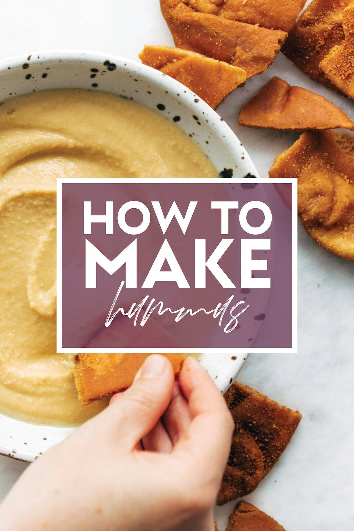 A bowl of hummus with pita on the side.