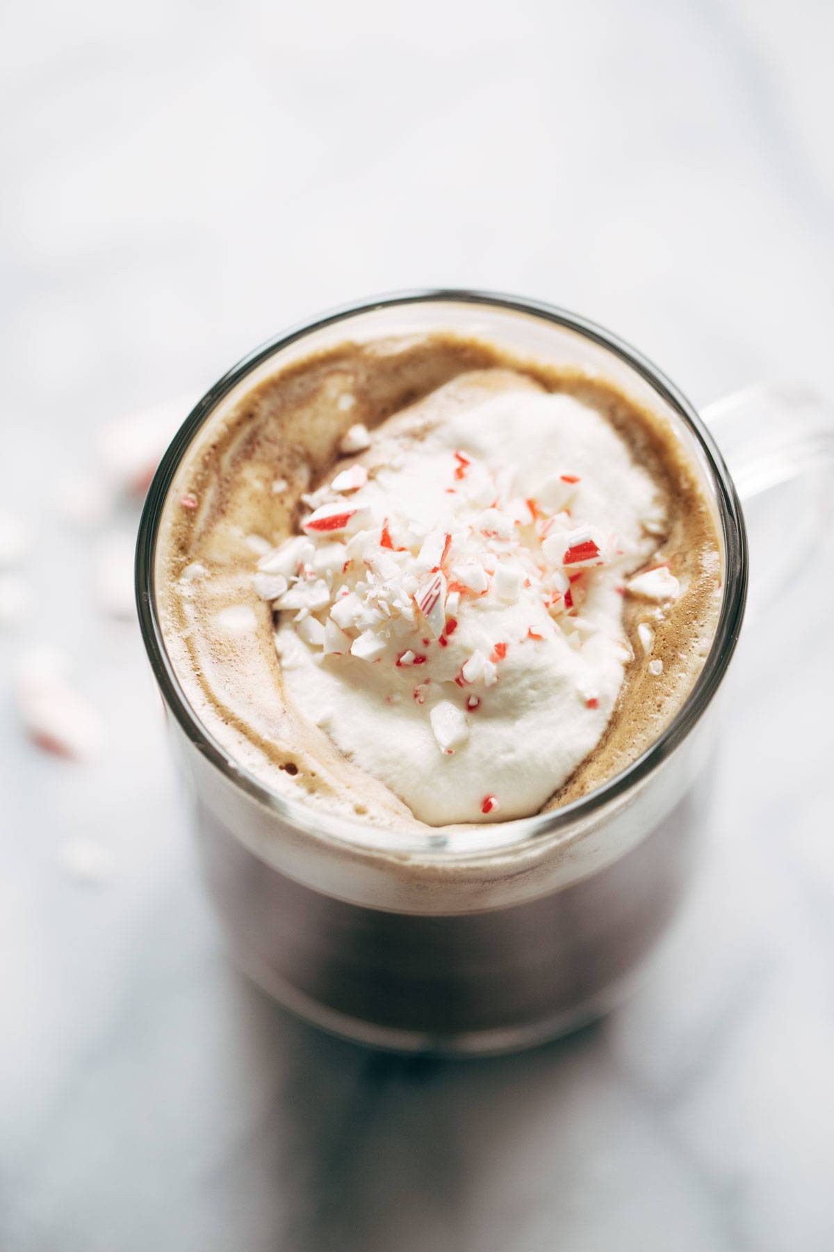 Overhead shot of peppermint mocha in a mug with crushed candy canes. 