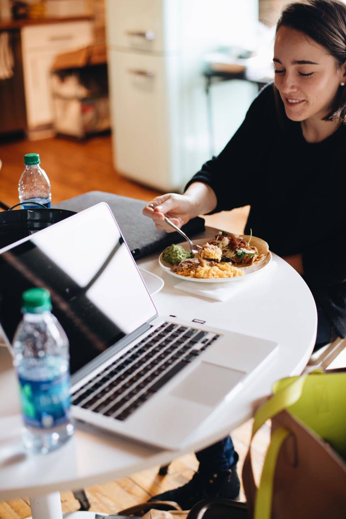 Woman eating food at a table.